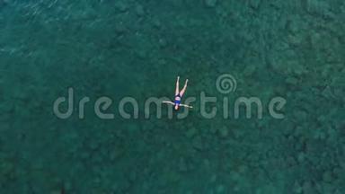空中：漂浮在蓝色水面上的女人，在透明的地中海游<strong>泳</strong>，从上<strong>往</strong>下看，夏季度假